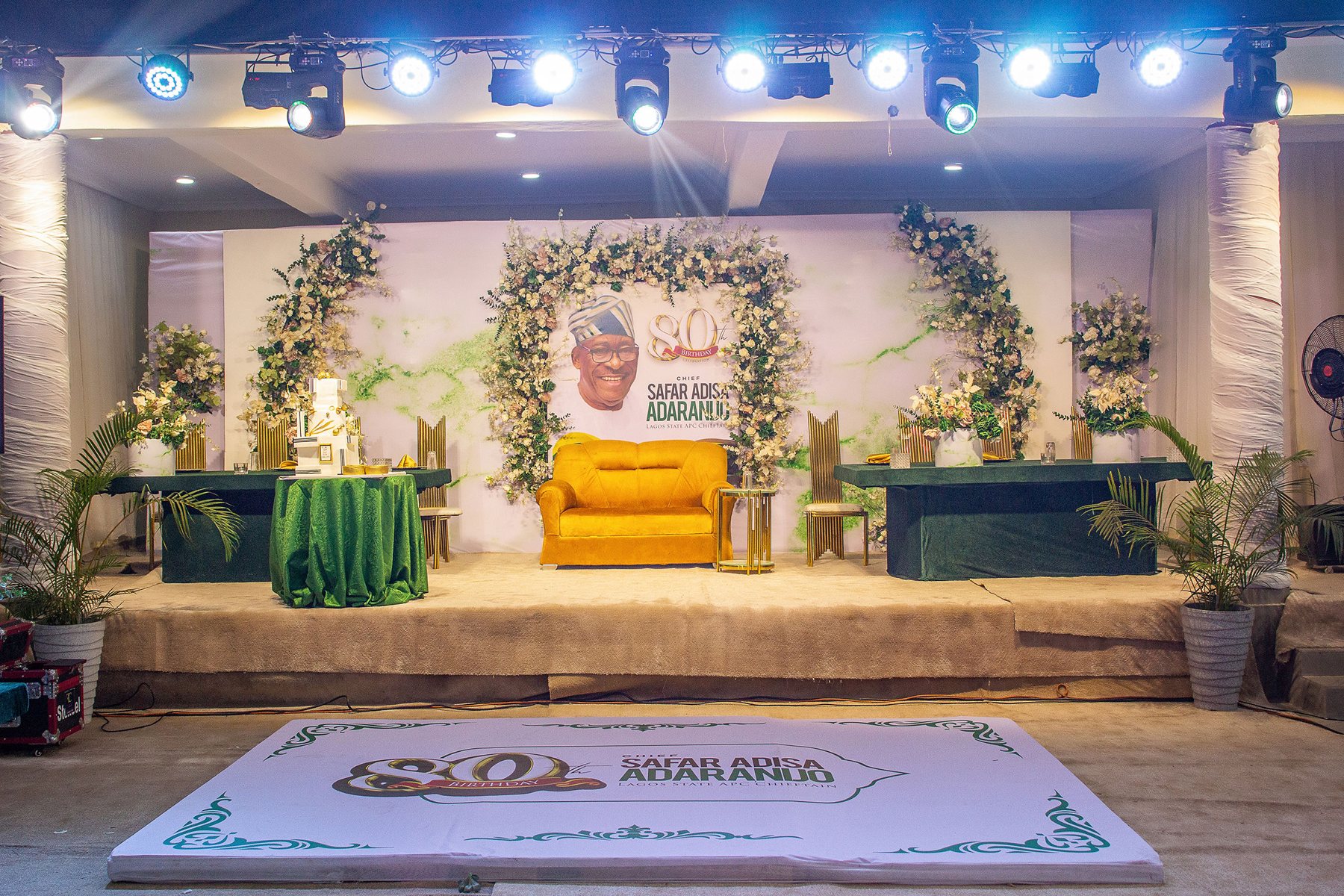 80th birthday event stage with green and gold decor